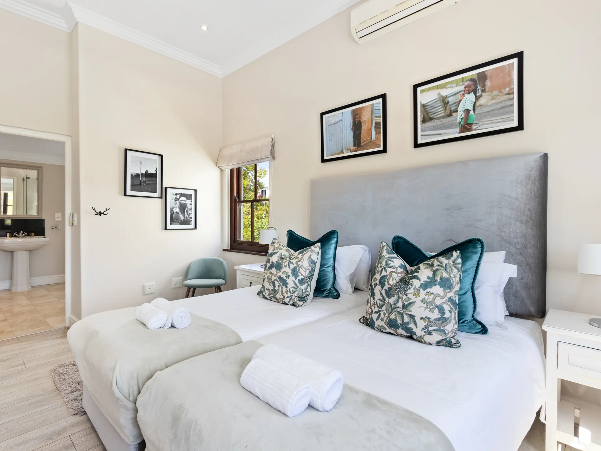 Second bedroom with teal cushions and en-suite bathroom