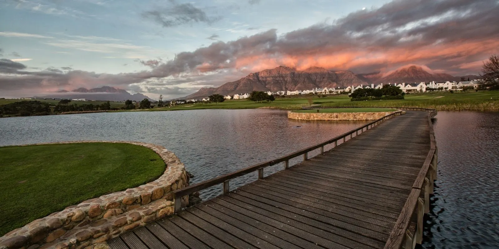 Wooden walkway at sunset with mountain backdrop