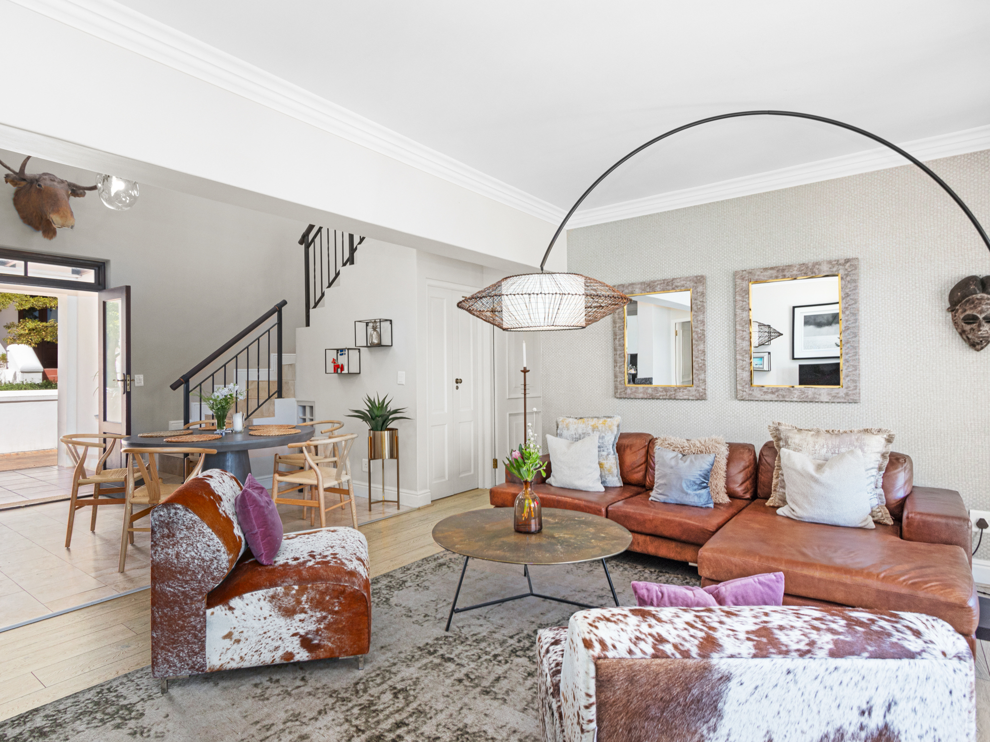 Open-plan living area with leather sofas and staircase