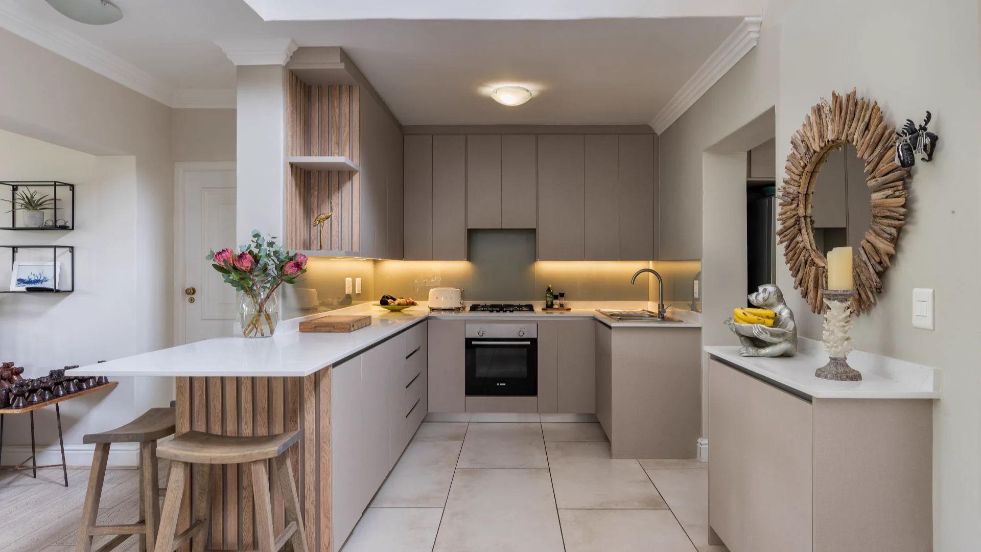 Fully equipped self-catering kitchen with breakfast bar, warm lighting and protea flowers in a lodge at Winelands Golf Lodges at De Zalze, Stellenbosch